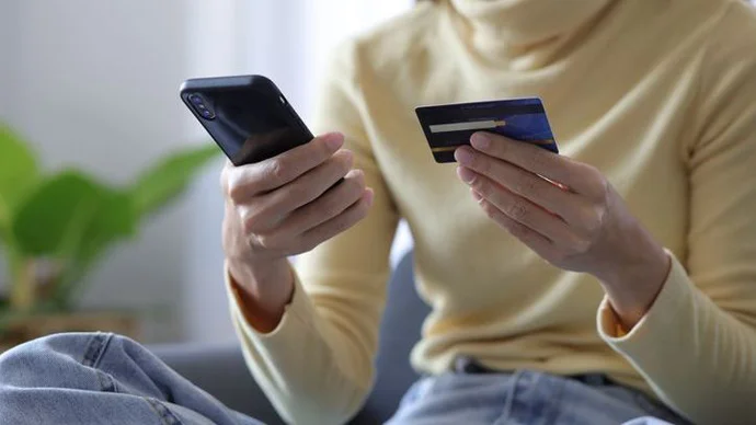 Woman making a payment on her phone with a gift card