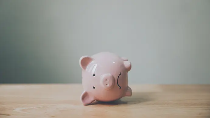 Woman with a questioning look holding a jar of money