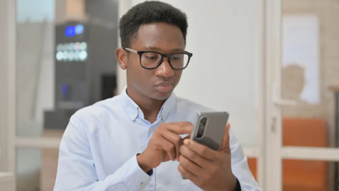 Watch Out for Phon(e)y Messages Man looking at scam text message