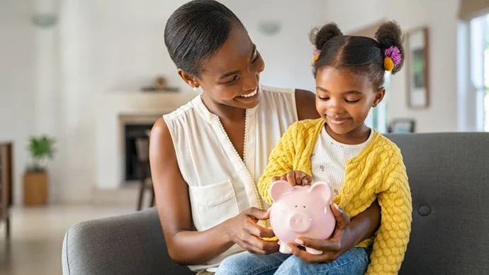 Parent handing their child some money for saving