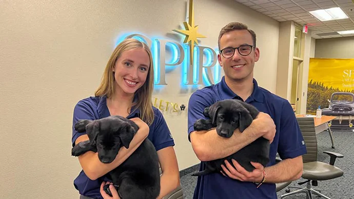 Two SPIRE interns holding puppies from Second Handhounds