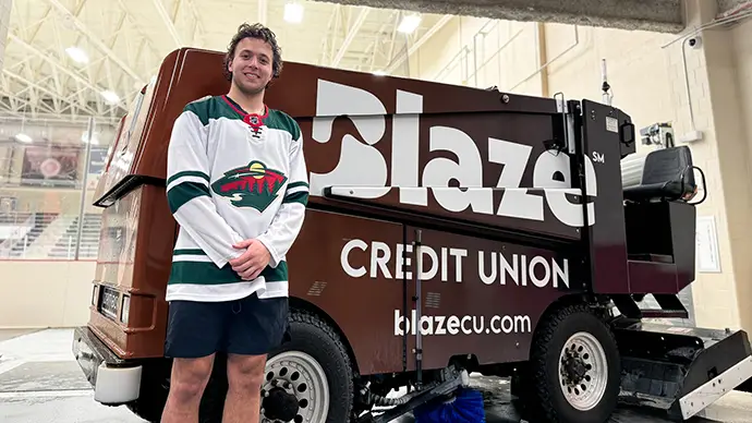 Brock Faber Blaze News Brock Faber smiles next a Blaze Credit Union zamboni