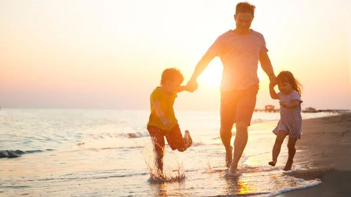 Vacation Means Re-Creation Family on the beach in the sunset